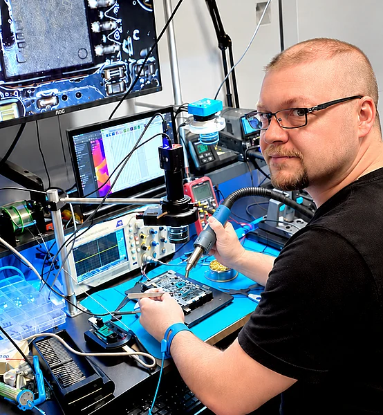 Edgar bei der Elektronikreparatur am Arbeitstisch mit Messgeräten und Löttechnik